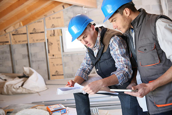 two construction workers review the plans
