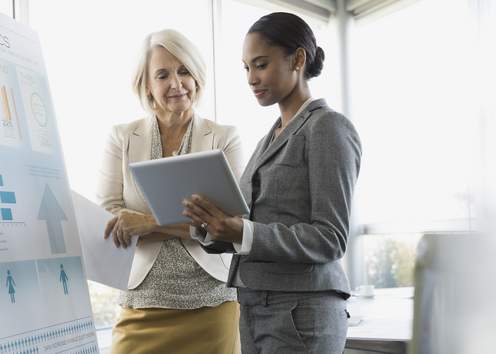 Women look at board together