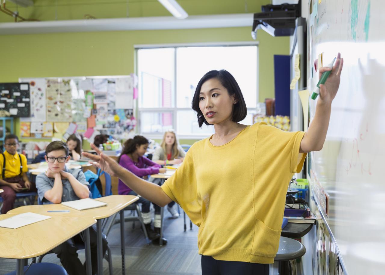 Teacher instructing a group of students inside a classroom