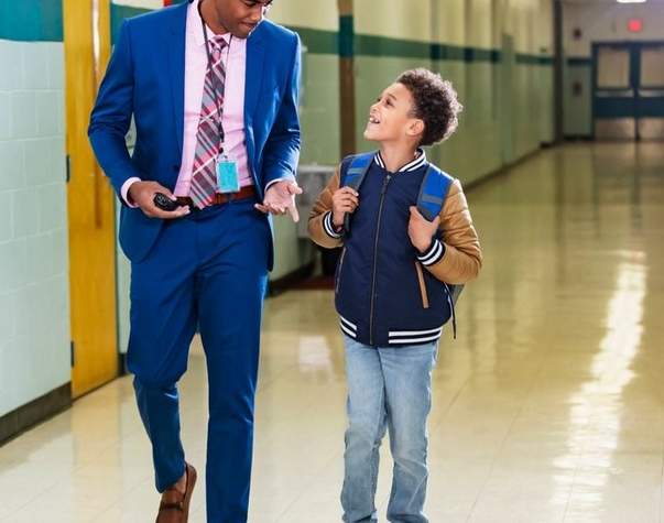 principal and student walking down a school hallway